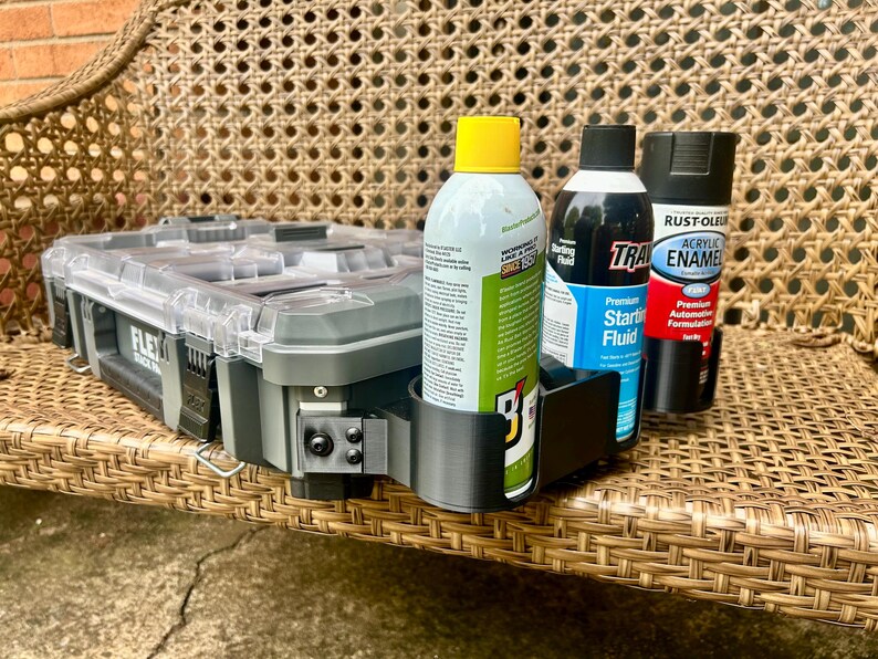 Peut inclure: Une mallette &agrave; outils en plastique gris avec un couvercle transparent et un support lat&eacute;ral noir imprim&eacute; en 3D contenant trois bombes a&eacute;rosols. Les bombes incluent un spray &agrave; bouchon jaune, un fluide de d&eacute;marrage bleu et un spray &eacute;mail noir.