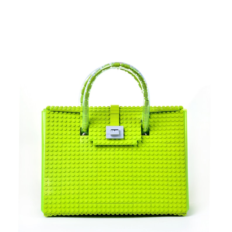 Peut inclure: Un sac &agrave; main vert lime en blocs de construction en plastique. Le sac a une poign&eacute;e sup&eacute;rieure et une fermeture &agrave; fermoir.