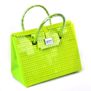 Peut inclure: Un sac &agrave; main vert lime enti&egrave;rement fait de briques Lego. Le sac a une poign&eacute;e sup&eacute;rieure et une fermeture &agrave; cl&eacute;.
