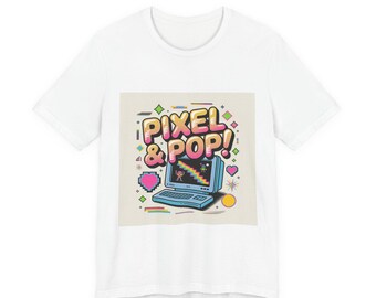 May include: White t-shirt featuring a retro-style graphic with the text "PIXEL & POP!" above a blue computer with a rainbow screen. The design includes pink hearts, stars, and geometric shapes, creating a vibrant, playful aesthetic.