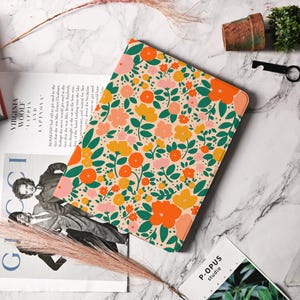 May include: A pink and cream floral patterned iPad case with green leaves and orange, yellow, and pink flowers.