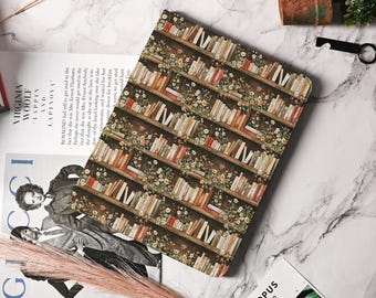 May include: A brown leather laptop sleeve with a repeating pattern of bookshelves filled with books and flowers. The bookshelves are brown with white trim. The books are a variety of colors and sizes. The flowers are a variety of colors and are in bloom.