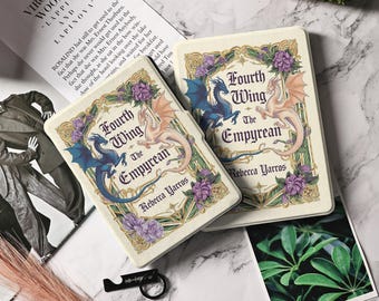 Puede incluir: Dos portadas de libros para "Fourth Wing: The Empyrean" de Rebecca Yarros. Las portadas presentan un diseño de dragón azul y melocotón con detalles florales morados. Las portadas de los libros están sobre una superficie clara.