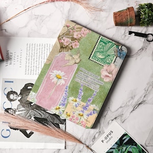 Pode incluir: Um diário decorativo com um design floral e vintage. A capa apresenta uma margarida, lavanda, um selo da Nova Zelândia e o texto "Never be so kind, You forget to be clever, You forget to be clever, Never be so kind."