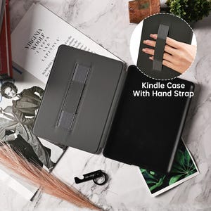 Pu&ograve; includere: Una custodia grigia per Kindle con un cinturino da polso. La custodia ha un supporto integrato e un cinturino elastico grigio per tenere il Kindle.