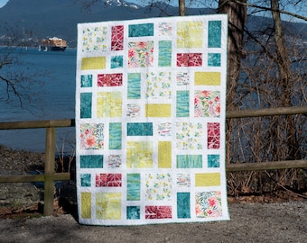May include: A patchwork quilt with a variety of colorful squares, including teal, yellow, red, and white. The quilt features floral and geometric patterns.