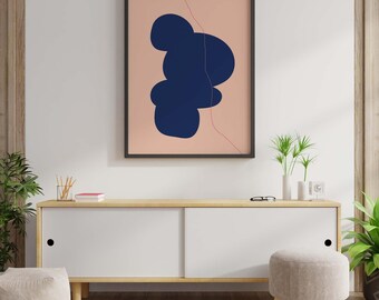 May include: A framed abstract art print featuring a navy blue organic shape on a peach background. A thin, red line accents the design. The artwork is displayed above a white cabinet with a wooden top, a small stool, and potted plants.