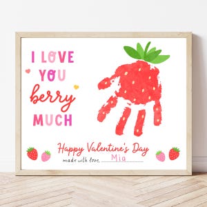 May include: A framed Valentine's Day print with a strawberry handprint design. The text reads "I love you berry much" in pink and red. The print also includes the text "Happy Valentine's Day" and two strawberry illustrations.