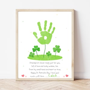 Pode incluir: Impressão emoldurada com um design de trevo de impressão de mão verde e trevos de quatro folhas. O texto diz: "Um trevo de impressão de mão feito só para você, cheio de amor e bons desejos. Feliz Dia de São Patrício, eu te amo!" Assinado "Caleb".