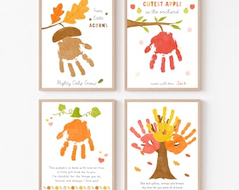 May include: Four framed art prints featuring handprint art. One print shows a brown acorn, another a red apple, a third an orange pumpkin, and the last a tree with red, yellow, and orange leaves. Each print has text.