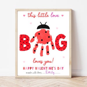Op de afbeelding: Een ingelijste Valentijnsdag print met een lieveheersbeestje handafdruk ontwerp. Het woord "BUG" is geschreven in rode letters met zwarte stippen. De tekst luidt "this little love" en "loves you!" met "HAPPY VALENTINE'S DAY" onderaan.