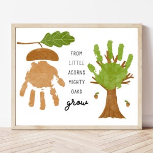May include: A framed print with handprint art of a tree and an acorn. The acorn is made from a handprint, and the tree is made from a green handprint. The text reads "From Little Acorns Mighty Oaks Grow."