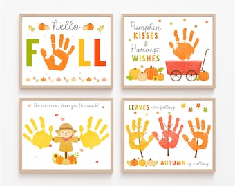 May include: Four framed prints with autumn-themed designs. One print says "hello FALL" with a handprint. Another says "Pumpkin Kisses & Harvest Wishes" with a handprint and pumpkins. The third says "The scarecrow loves you this much!" with handprints and a scarecrow. The last says "LEAVES are falling" with handprints and pumpkins.