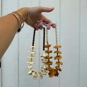 Guirlanda floral artesanal para carro com contas difusoras.