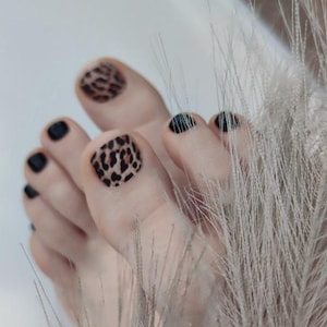 Könnte beinhalten: Ein Set aus drei Keramikbechern mit gesprenkelter, matter Oberfläche. Die Becher sind in Creme-, Hellgrau- und Dunkelgrautönen gehalten. Jeder Becher hat ein schlichtes, minimalistisches Design.