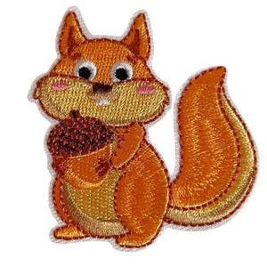 Könnte beinhalten: Gestickter Aufnäher mit einem Cartoon-Eichhörnchen, das eine Eichel hält. Das Eichhörnchen hat orangefarbenes und hellbraunes Fell, schwarze Augen und rosa Wangen. Der Aufnäher hat einen weißen Rand und ist für Kleidung oder Accessoires geeignet.