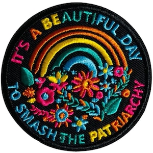 Könnte beinhalten: Gestickter Aufnäher mit schwarzem Hintergrund, mit einem Regenbogen und floralem Design. Der Text lautet "It's a beautiful day to smash the patriarchy" in einem kreisförmigen Muster um das Design.