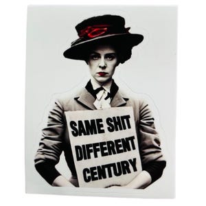 Könnte beinhalten: Aufkleber mit einer Frau in schwarzem Hut und Anzug, die ein Schild mit der Aufschrift "SAME SHIT DIFFERENT CENTURY" hält. Die Frau trägt roten Lippenstift und hat einen ernsten Gesichtsausdruck.
