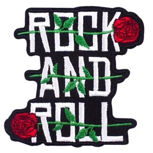 Könnte beinhalten: Schwarzer, gestickter Aufnäher mit den Worten "ROCK AND ROLL" in weißen Blockbuchstaben. Rote Rosen und grüne Ranken akzentuieren das Design und schaffen eine klassische Rock'n'Roll-Ästhetik.