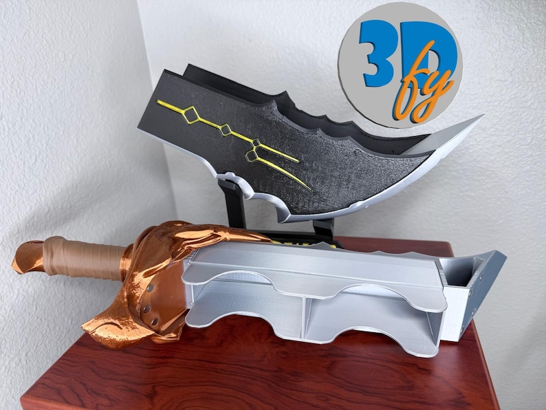 May include: A 3D-printed fantasy sword and blade display. The sword features a bronze-colored hilt and blade guard, with a light gray blade. The blade is black with yellow accents. The logo "3D by" is in a circle in the background.