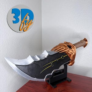 May include: A large, decorative sword with a silver blade and a black handle. The sword features gold accents and is displayed on a black stand. The text "3D by" is visible in a circular logo in the upper left corner.