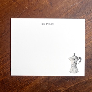 Op de afbeelding: Een witte kaart met de naam "Julia Miraletti" in zwarte tekst bovenaan. Een zwart-witte illustratie van een traditionele Italiaanse koffiepot bevindt zich rechtsonder.