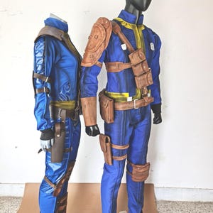 May include: Two blue and brown cosplay costumes with leather straps and pouches. The costumes are on mannequins.
