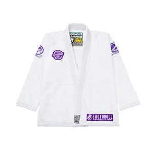 Puede incluir: Gi blanco de Jiu-Jitsu con marcas y logotipos Shoyoroll morados. El Gi presenta un diseño tradicional con un cuello blanco y un cinturón blanco.