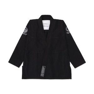 Pode incluir: Gi de artes marciais preto com gola em V. O gi apresenta um patch em cada ombro e um patch retangular na parte inferior da frente. O nome da marca é visível na gola. Este uniforme foi concebido para treino e competição de artes marciais.