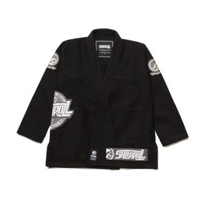 Pode incluir: Kimono de Jiu-Jitsu preto com logotipos brancos e cinzentos. O kimono apresenta um design de decote em V e vários patches com o nome da marca e outros gráficos. O kimono foi concebido para treino e competição de artes marciais.