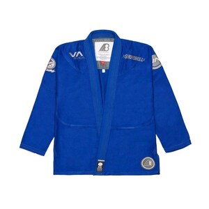 Pode incluir: Um gi de Jiu-Jitsu azul com os logotipos RVCA e Shoyoroll. O gi tem um design de gola em V e vários patches. Feito de um material durável, é projetado para treinamento e competição em artes marciais.