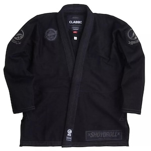Pode incluir: Kimono de Jiu-Jitsu preto com o texto "CLASSIC" e "SHOYOROLL" na jaqueta. O Gi tem um design tradicional com um cinto preto e uma gola branca.
