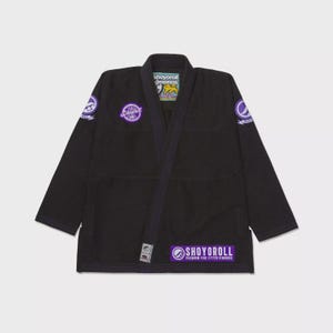 Pode incluir: Kimono de Jiu-Jitsu preto com detalhes roxos e o texto "Shoyorolli Premium Fine Fitted Kimonos".