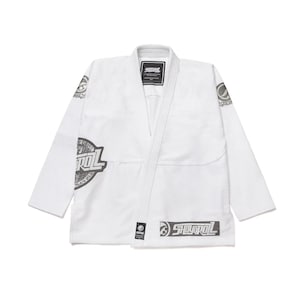 Pode incluir: Uniforme branco de artes marciais com o nome da marca "Storm" impresso em cinza no peito, ombro e bainha inferior. O uniforme tem um design de decote em V e é feito de um tecido durável. Projetado para treinamento e competição de artes marciais.