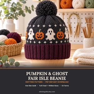 May include: A dark charcoal gray knit beanie featuring a repeating pattern of white ghosts and orange jack-o'-lanterns. The hat has a deep purple ribbed cuff and a large matching dark charcoal pom-pom on top. The text reads PUMPKIN & GHOST FAIR ISLE BEANIE.