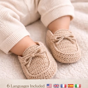 Könnte beinhalten: Ein Paar beige gehäkelte Babyschuhe mit Schleifen. Die Schuhe sind auf einer weichen, strukturierten Oberfläche abgebildet. Der Text "Crochet and Stitching Villa" und "6 Languages Included" sind ebenfalls zu sehen.