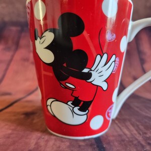 Puede incluir: Taza de cer&aacute;mica roja con Mickey Mouse. La taza tiene un asa blanca y est&aacute; decorada con lunares blancos y peque&ntilde;os corazones rosas. Una adici&oacute;n divertida y colorida a la colecci&oacute;n de cualquier fan de Disney.