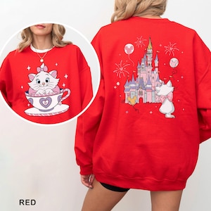 A red sweater with a cartoon image of a cat and a castle on the back.