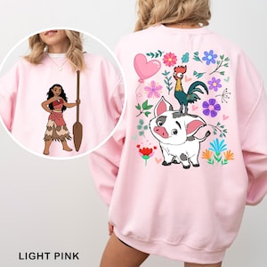 a woman wearing a pink sweatshirt with a cartoon character on it