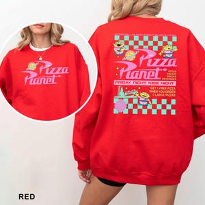 A red sweatshirt with a colorful design featuring characters from the movie "Pizza Planet".