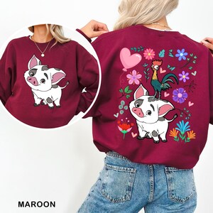 a woman wearing a maroon sweatshirt with a picture of a dog on it