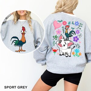 a woman wearing a sweatshirt with a rooster and rooster on it