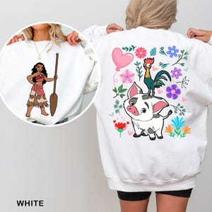 a woman wearing a white sweatshirt with a picture of a cartoon character on it