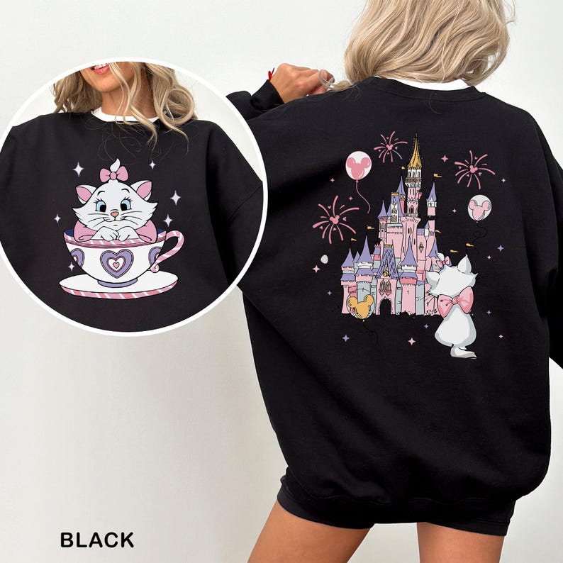 A black sweatshirt with a pink and white cat and a castle on it, along with fireworks in the background.