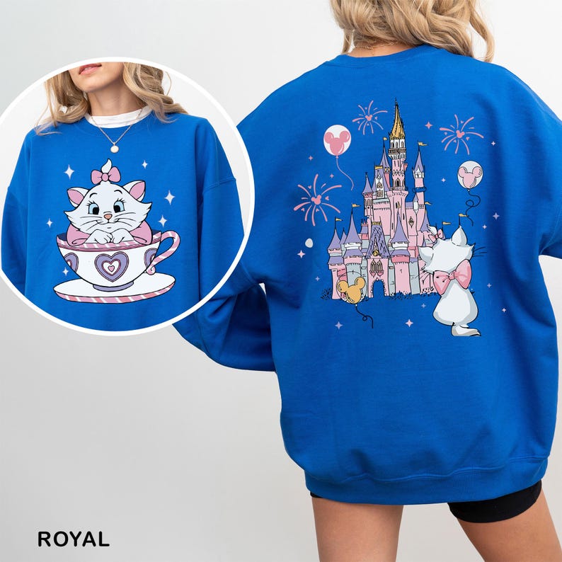 A person wearing a blue sweatshirt with a cartoon image of a cat and a castle on the back.