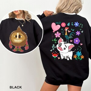 a woman wearing a black sweatshirt with a picture of a pig on it
