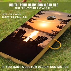 Könnte beinhalten: Ein hölzernes Cornhole-Brett mit einem aufgedruckten Sonnenuntergangs-Motiv. Die Szene zeigt zwei Stühle am Ufer eines Sees mit einem Sonnenuntergang im Hintergrund. Das Brett ist 62,2 cm x 123,2 cm groß.