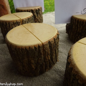 May include: Four rustic wooden table number holders with a split top for inserting a card. The card in the image reads "Table 4".