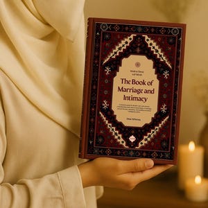 Puede incluir: Un libro de tapa dura titulado "The Book of Marriage and Intimacy" se sostiene en una mano. El libro tiene una cubierta burdeos con un diseño geométrico adornado en tonos de rojo, negro y blanco. El título está en una fuente decorativa.