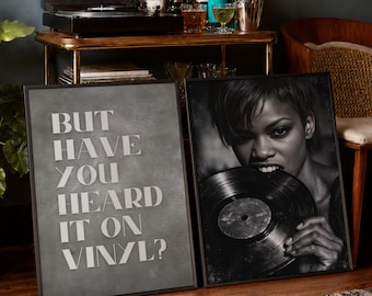 May include: Two framed rectangular wall art pieces. The left piece features a gray background with the white text, "BUT HAVE YOU HEARD IT ON VINYL?" The right piece is a black and white photograph of a person biting into a black vinyl record.